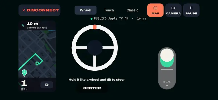 The iPhone as the controller, sideways: Map, Camera and Pause up top; on the left the mini-map with the route and the next turn; the wheel and the pedal